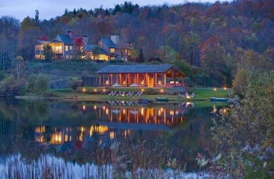 Twin Farms at dusk, its cottages lit above the pond